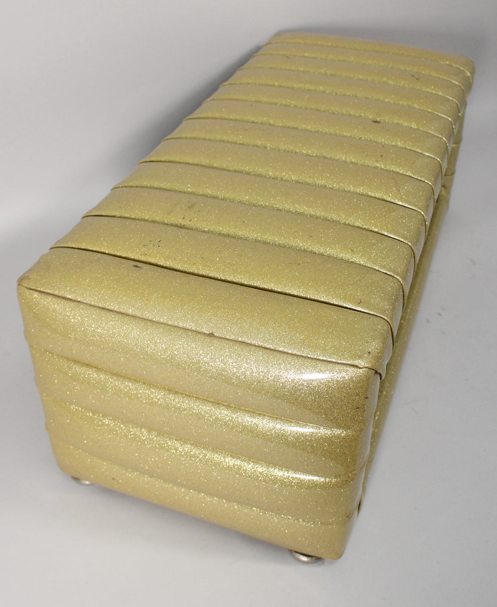 Top-down view of the gold sparkle PA head, showing the ribbed, padded exterior and two silver feet on the near side.
