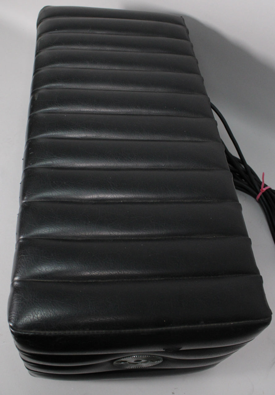The black tuck-and-roll amp head is viewed from above, showing the ribbed top and a single silver control knob on the front.