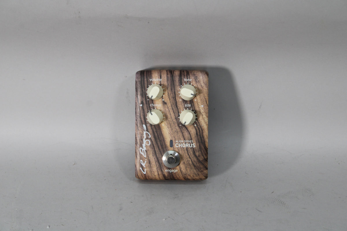 A top-down view of a chorus pedal with a dark woodgrain finish, four cream-colored knobs, and a silver footswitch.