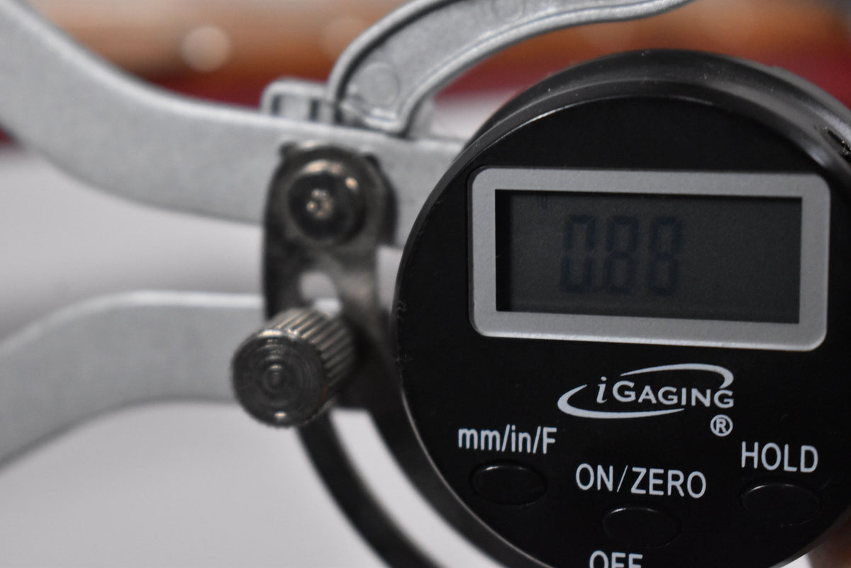 A close-up of a digital caliper with a reading of "0.00" on its display.