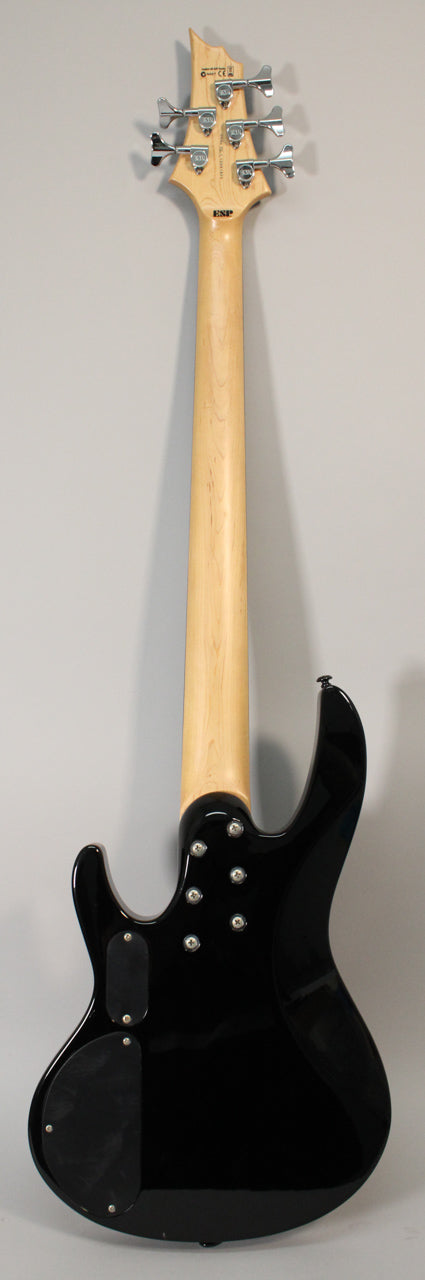 Rear view of a black 5-string bass with a natural wood neck, chrome tuners, and two black control cavity covers.