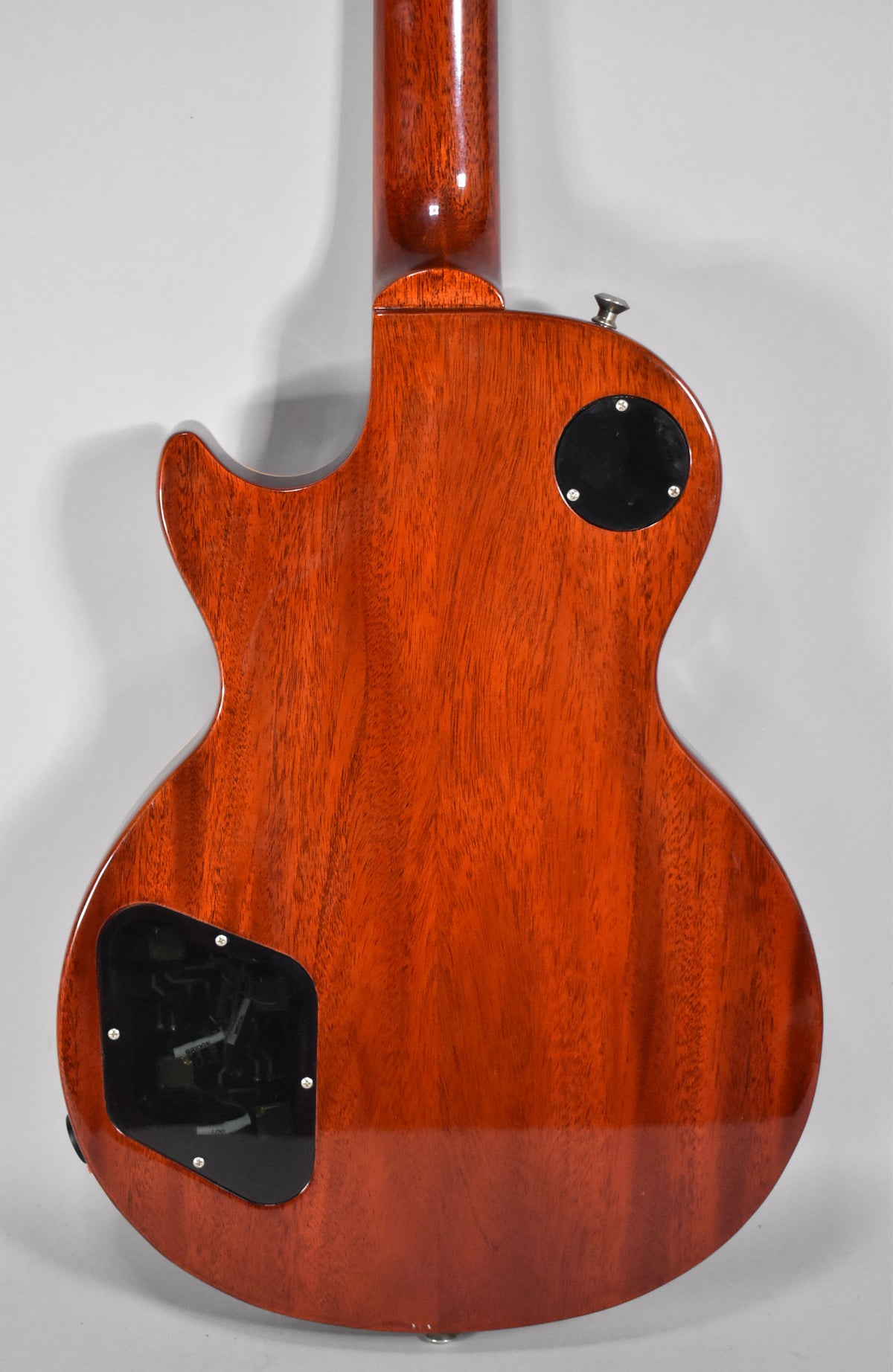 The back of the guitar, showing the mahogany body and neck with a glossy finish, and two black control cavity covers.
