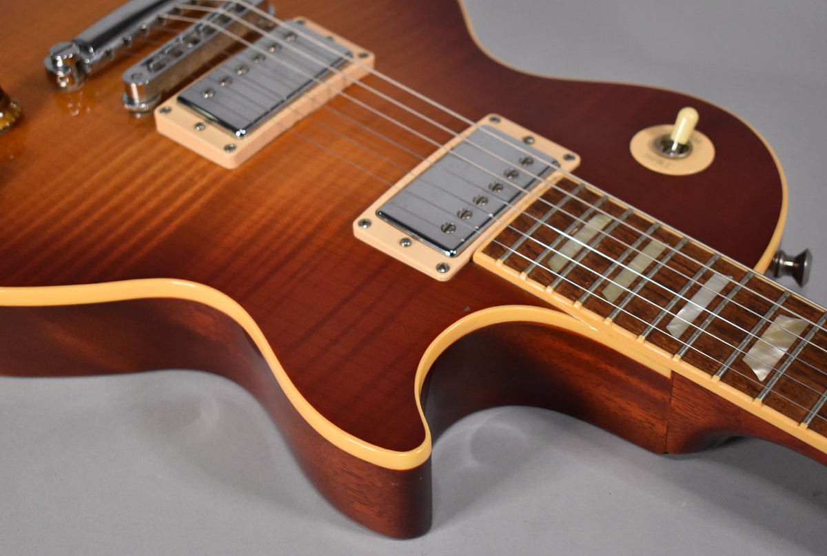 Close-up of the Les Paul's cherry sunburst body, showing the bridge pickup, neck, and lower horn with cream binding.