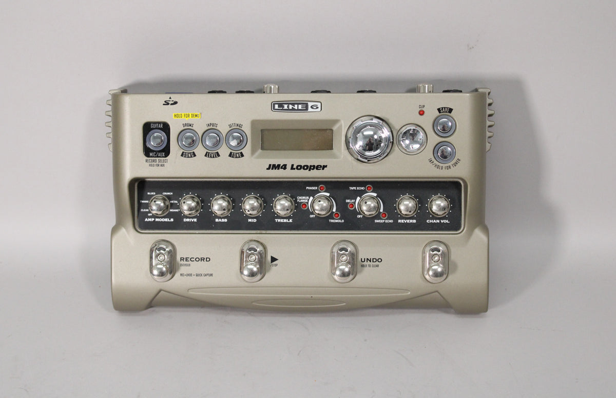 A top-down view of a beige Line 6 JM4 Looper pedal with a black control panel, a small screen, and four silver footswitches.