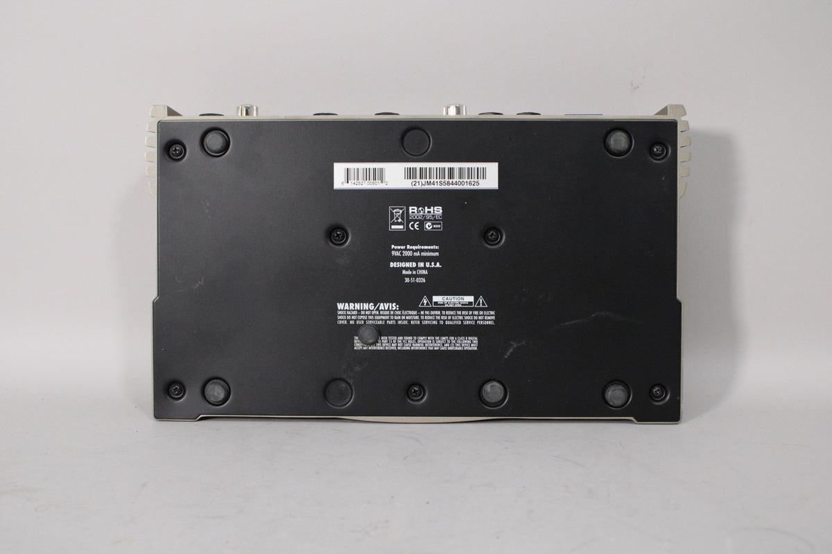 The black underside of a Line 6 JM4 Looper pedal with a barcode, serial number, and warning labels.
