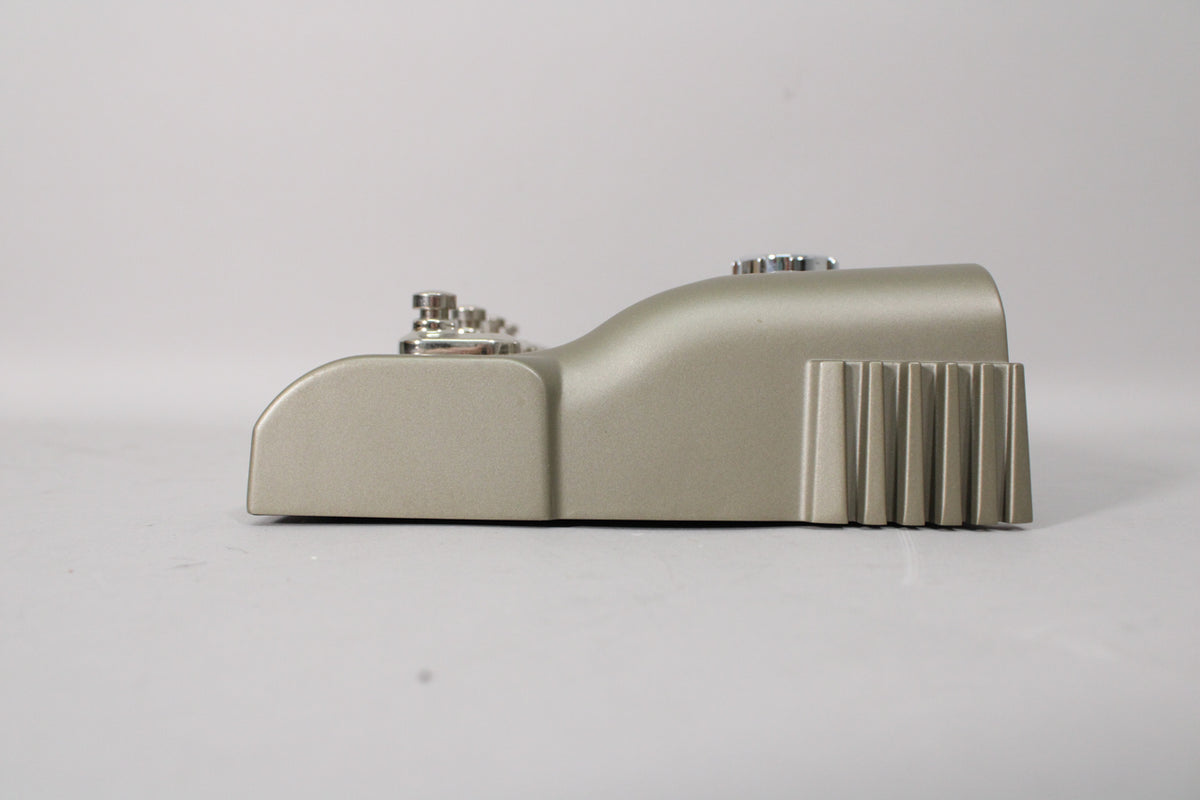 The Line 6 JM4 Looper pedal is shown from the right side, revealing its champagne finish, chrome knobs, and ribbed rear panel.
