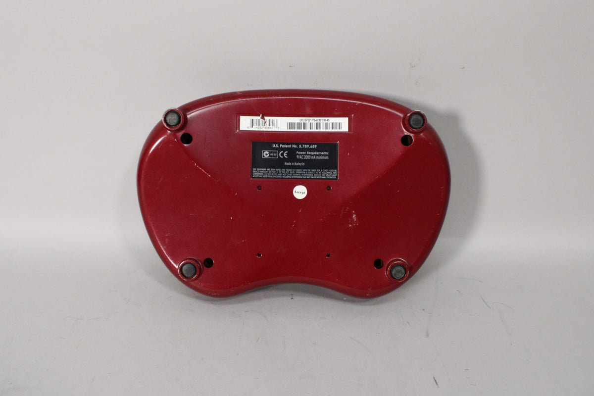 The Line 6 POD XT's dark red, kidney-shaped underside is visible, showing four black rubber feet and a central information sticker.