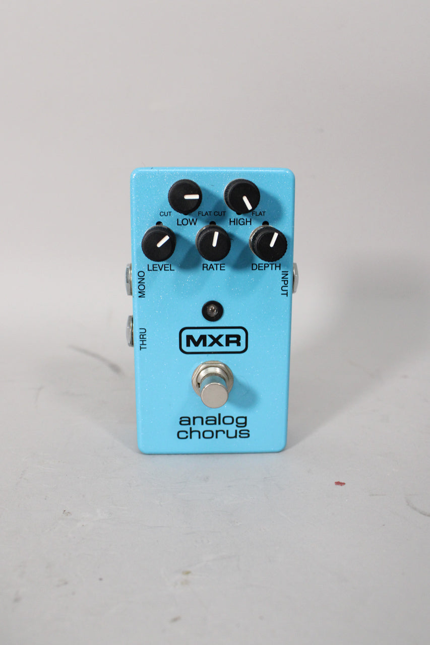 Light blue glitter-finish pedal, angled slightly, showing six black knobs, a footswitch, and input/output jacks.