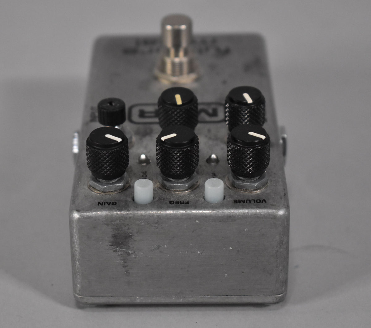 A silver MXR M116 Fullbore Metal Distortion Pedal with black knobs and white indicators, showing wear and tear.