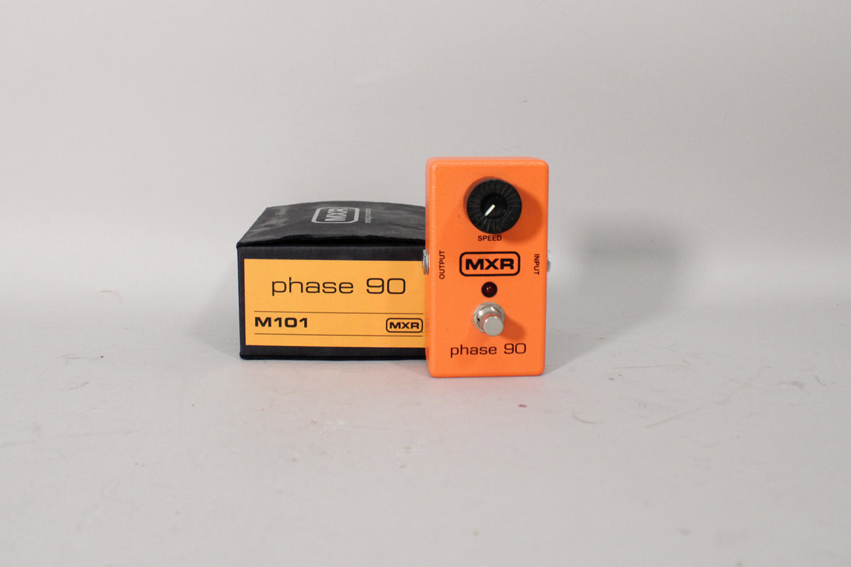An orange pedal with a single black speed knob, red LED, and chrome footswitch, next to its black box with yellow label.
