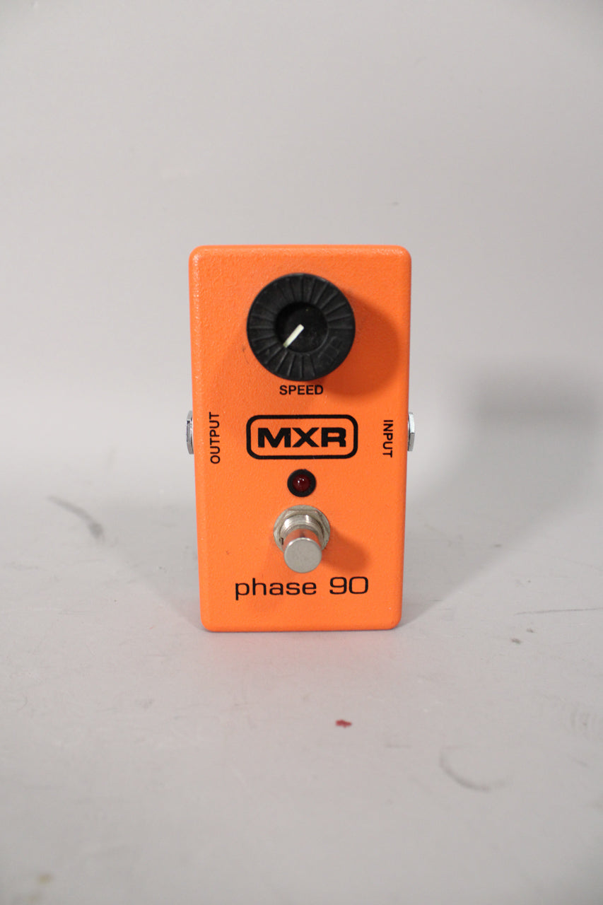 An orange effects pedal, viewed from the front, with a black speed knob, red indicator light, and a silver footswitch.