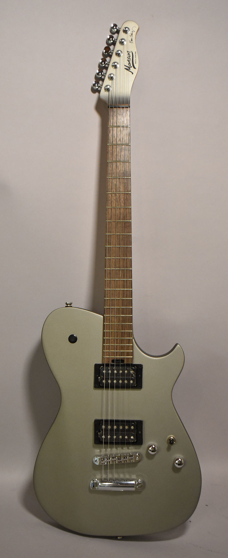 Full-length view of a silver-grey electric guitar with a matte finish, two black humbuckers, and chrome hardware.