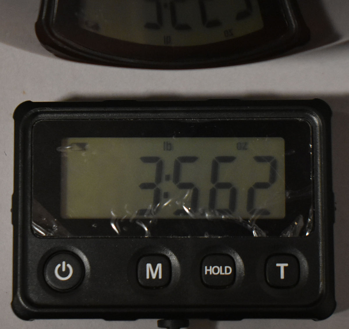 A digital scale displays the guitar's weight as 3 pounds, 5.62 ounces, with a scratched screen protector.