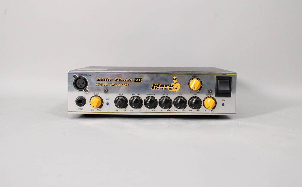 Front view of a silver amp head with a brushed finish, featuring yellow and black control knobs and a large power switch.