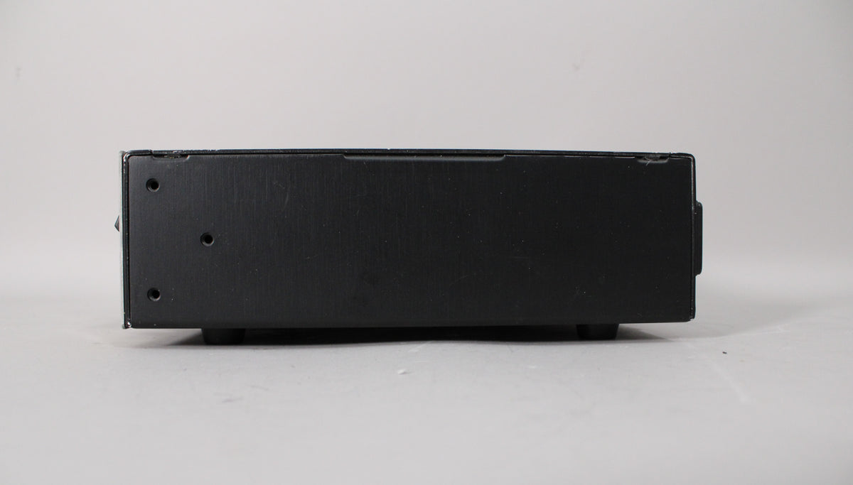 The amp head is viewed from the rear, showing a black brushed metal finish with three small screw holes on the left side.
