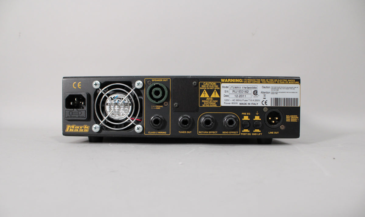 The silver amp head's rear panel is visible, showing a power input, fan, speaker out, and various effect loop and line out jacks.