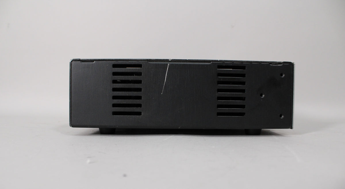 The amp head's black metal top panel, viewed from the rear, shows two vented sections and a long diagonal scratch.