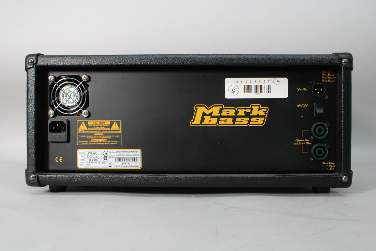 The black amp head's rear panel is visible, featuring a cooling fan, power input, XLR and two 1/4-inch speaker outputs, and a ground lift switch.