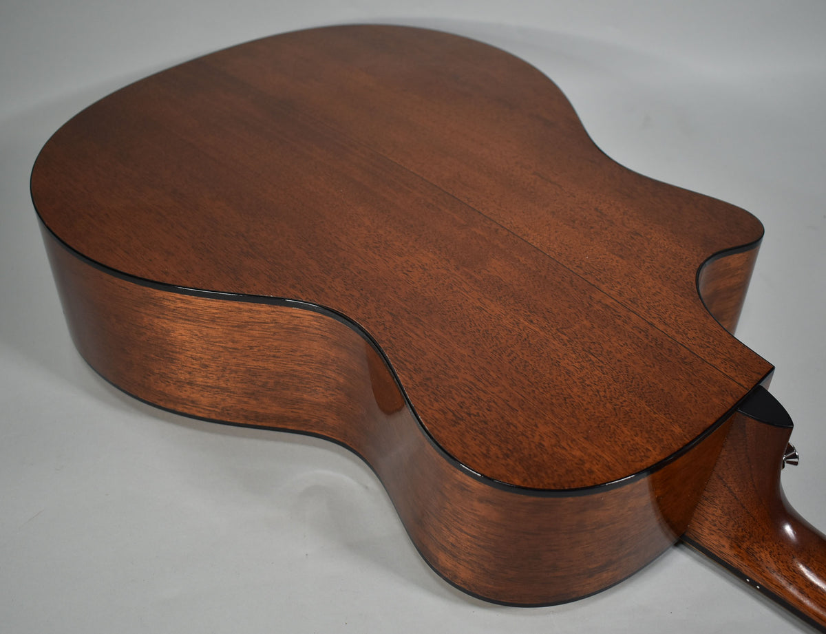 The guitar's dark brown back and sides are shown from above, with a cutaway visible on the lower bout.