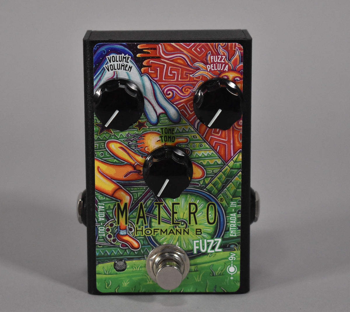 A black fuzz pedal with a vibrant, psychedelic illustration, three black control knobs, and a silver footswitch.