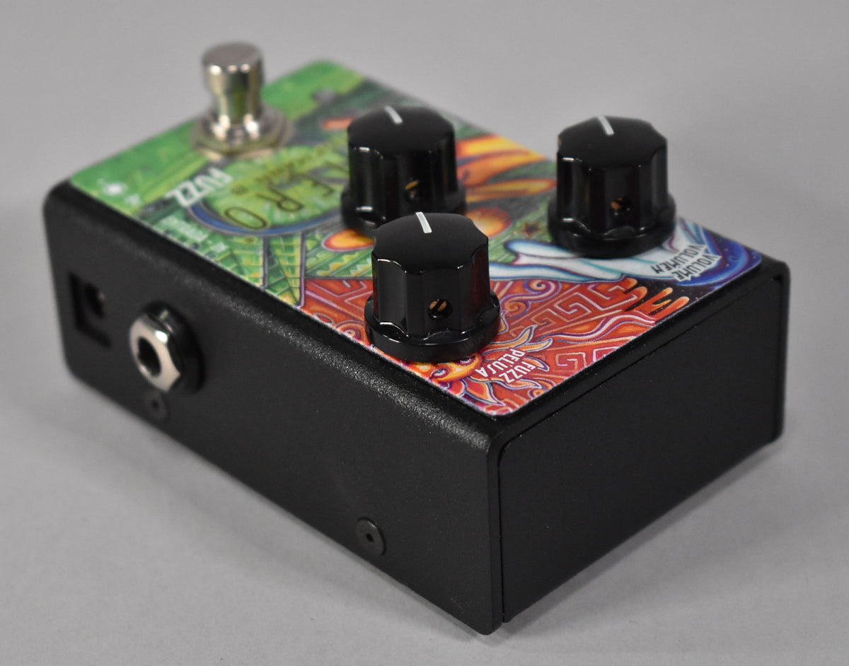 Black fuzz pedal with a colorful, patterned top, three black control knobs, and a silver footswitch and input jack.