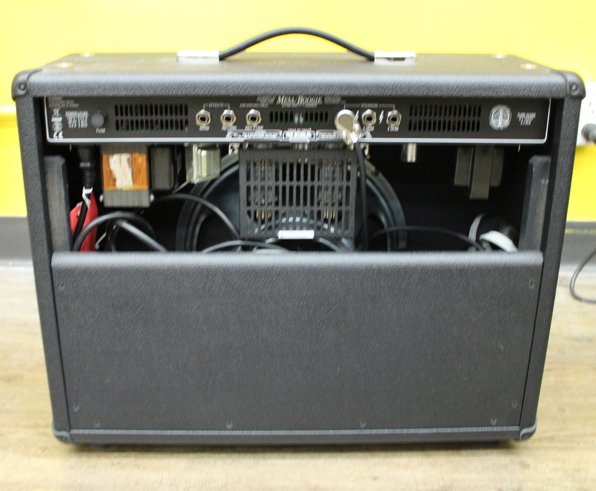 Rear view of a black textured combo amp, showing the open back with internal components, speaker, and rear control panel.