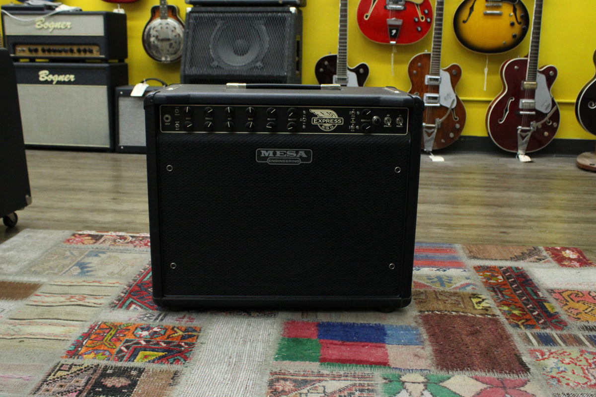 Black combo amp, front view, with a black grille and a silver control panel featuring many knobs and switches.