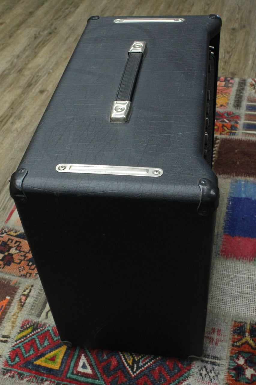Top-down view of the black textured amp, showing the ribbed handle, metal corner protectors, and some scuffs on the tolex.