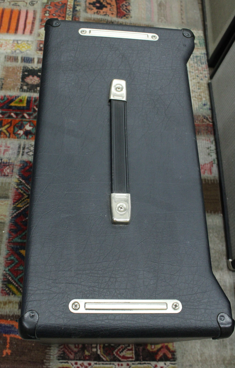 Top-down view of the black textured amp, showing the centered black handle with chrome ends, and two chrome vent strips.