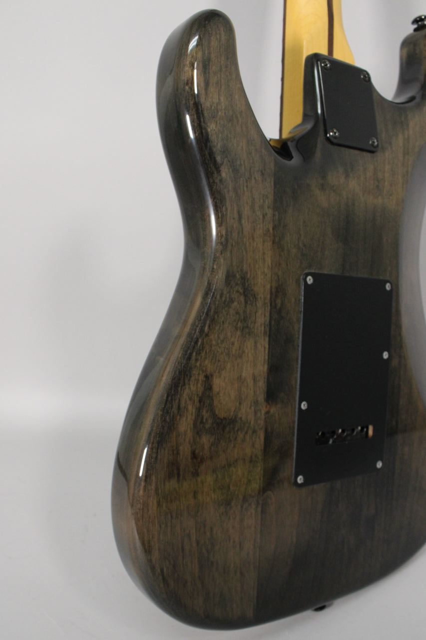 The back of a gloss trans gray electric guitar, angled right, showing the lower horn, neck joint, and tremolo cavity cover.