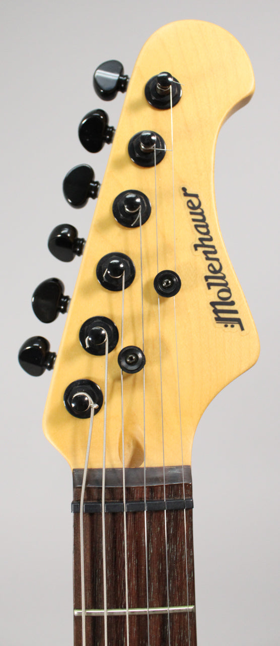 Close-up of the light wood headstock with black tuners, showing the top of the dark fretboard and nut.