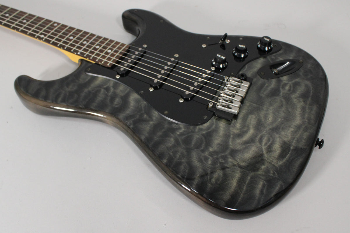 The electric guitar's body, with a gray swirled wood grain, is angled from the lower right, showing black pickups and chrome hardware.