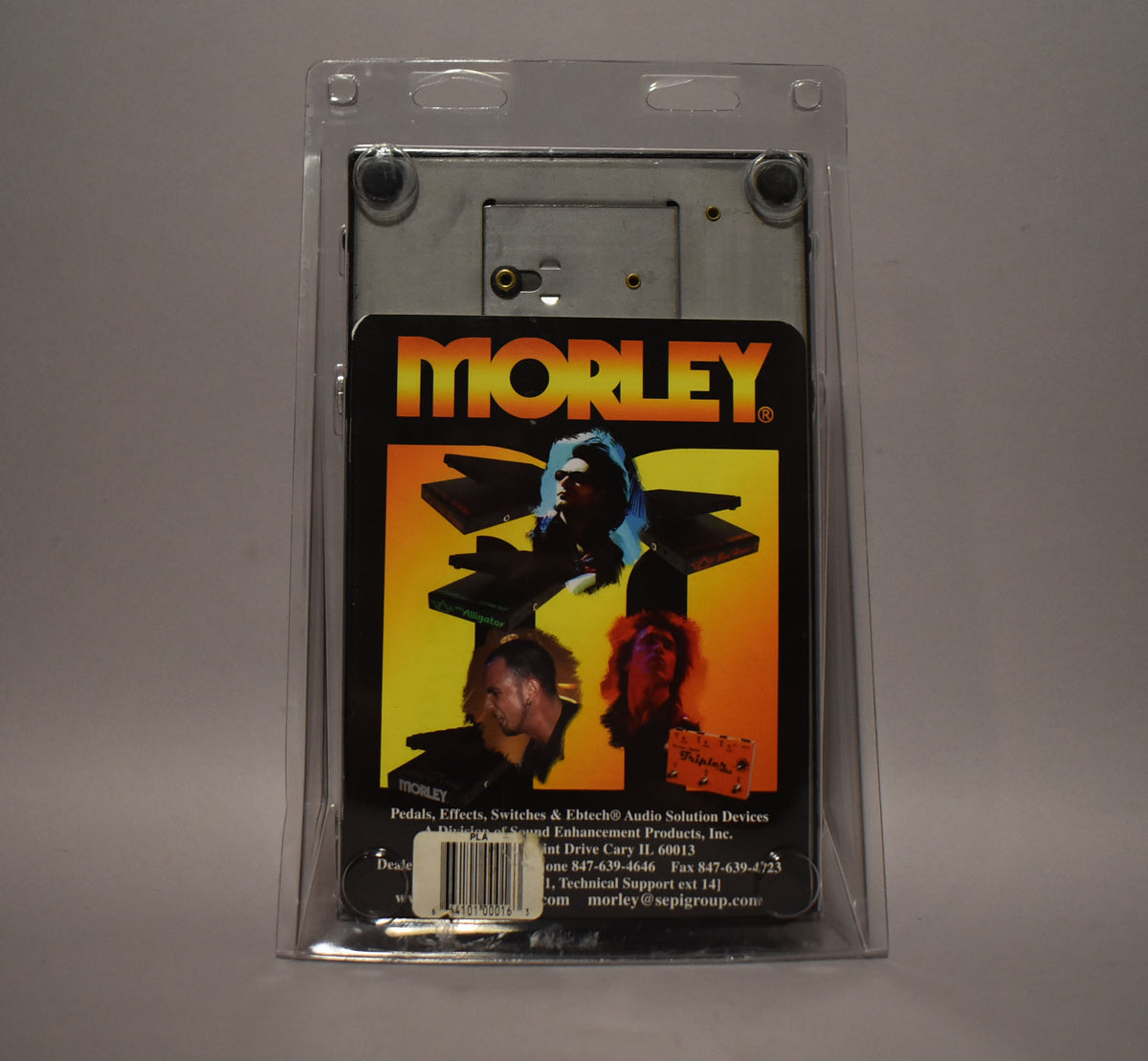 The pedal is seen from the back, still sealed in its clear plastic blister packaging with a colorful product card.