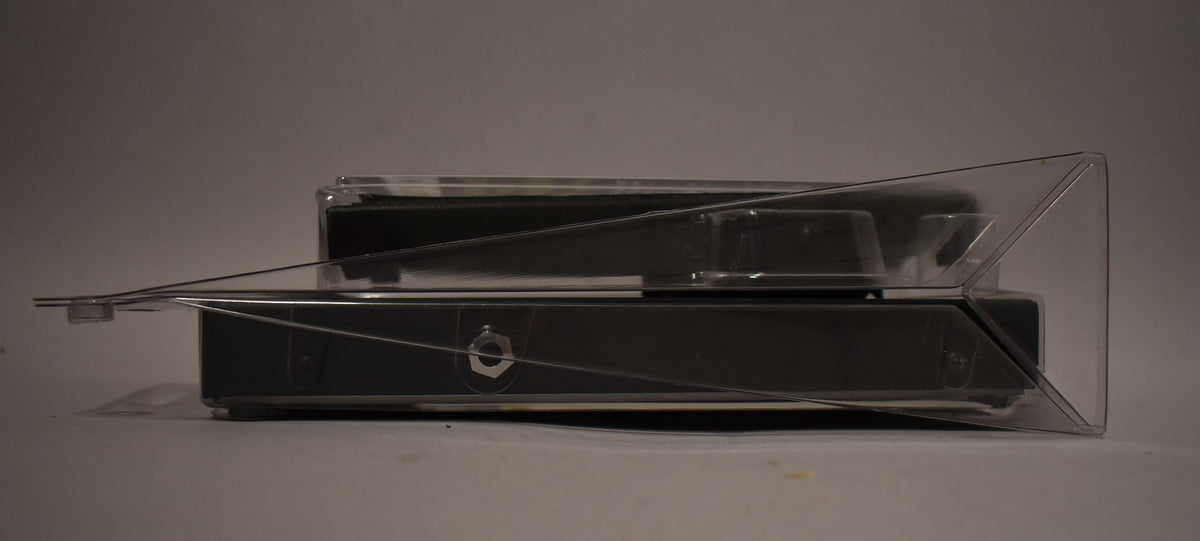 The black volume pedal is shown from the side, still sealed in its clear plastic blister packaging.