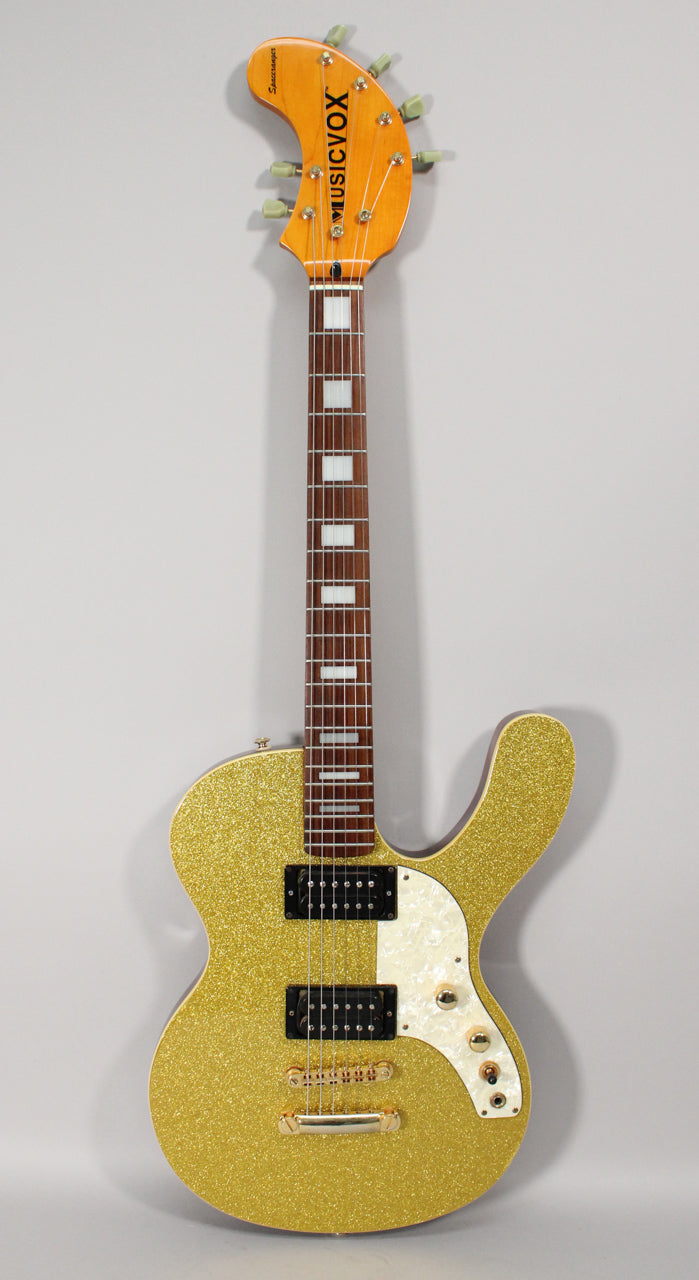 Full-length view of a gold sparkle electric guitar with a pearloid pickguard, two humbuckers, and gold hardware.