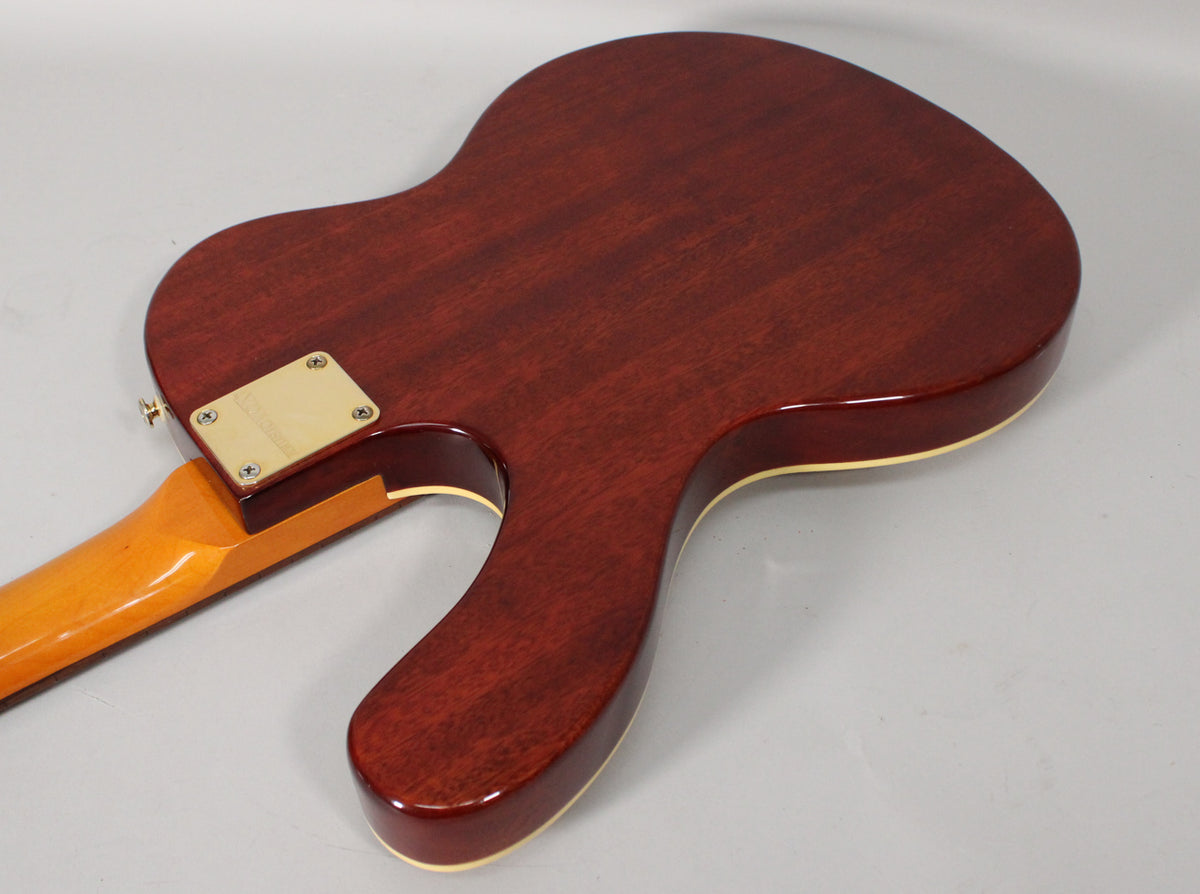 The guitar's back is a dark cherry wood finish with cream binding, showing a gold neck plate and a light wood neck.
