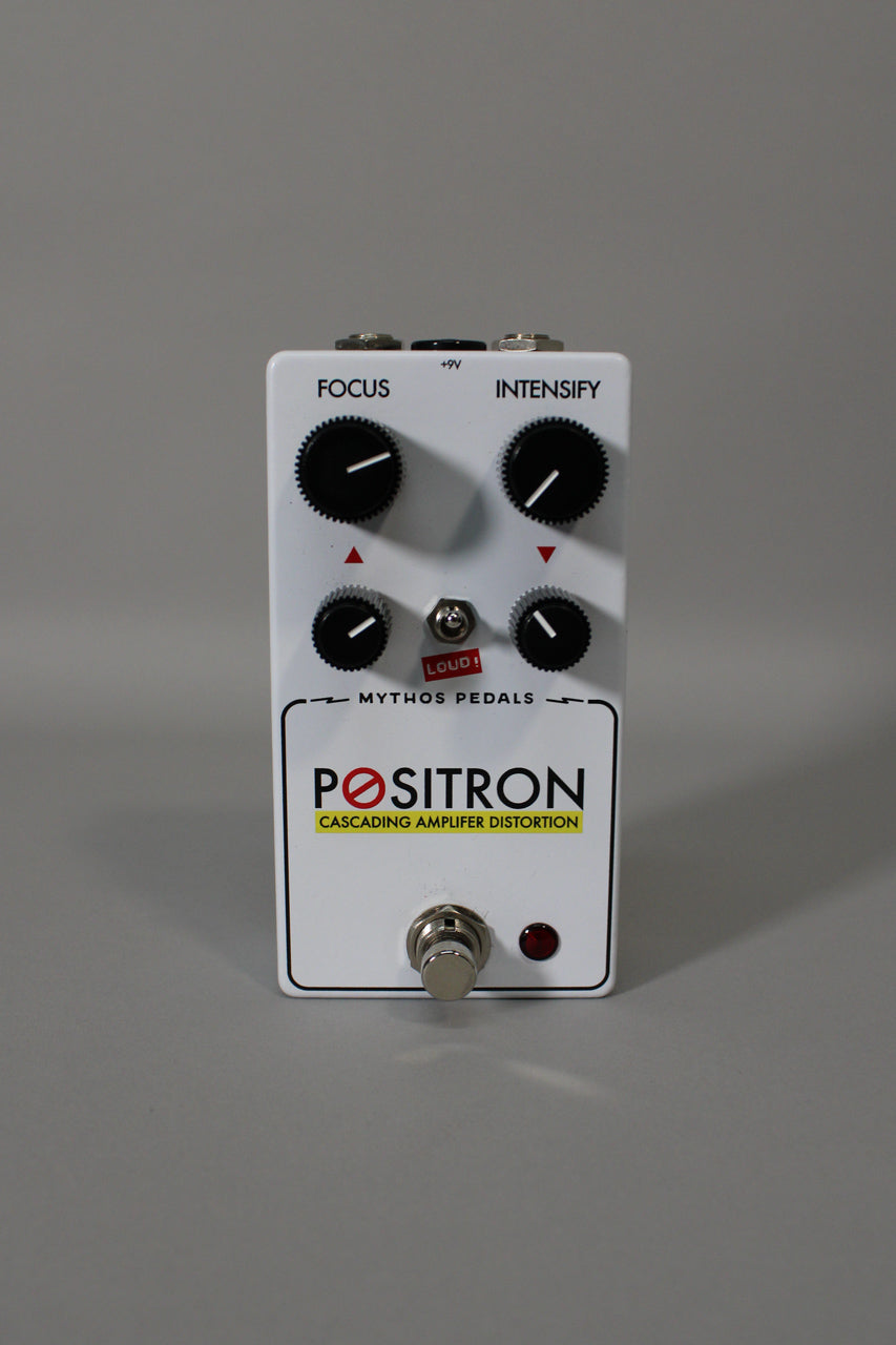 A white guitar pedal, viewed from above, features four black knobs, a silver footswitch, a red LED, and a small red "LOUD!" switch.