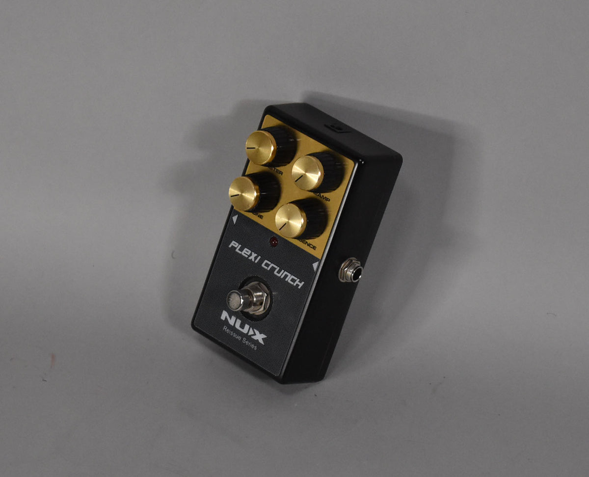 Black guitar pedal with a gold control panel, four gold knobs, and a silver footswitch, viewed from above at an angle.