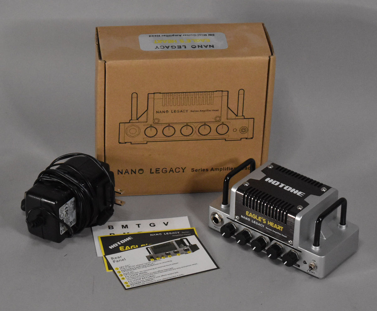 Silver and black mini amp head with five black knobs, two black handles, a power supply, manual, and original box.