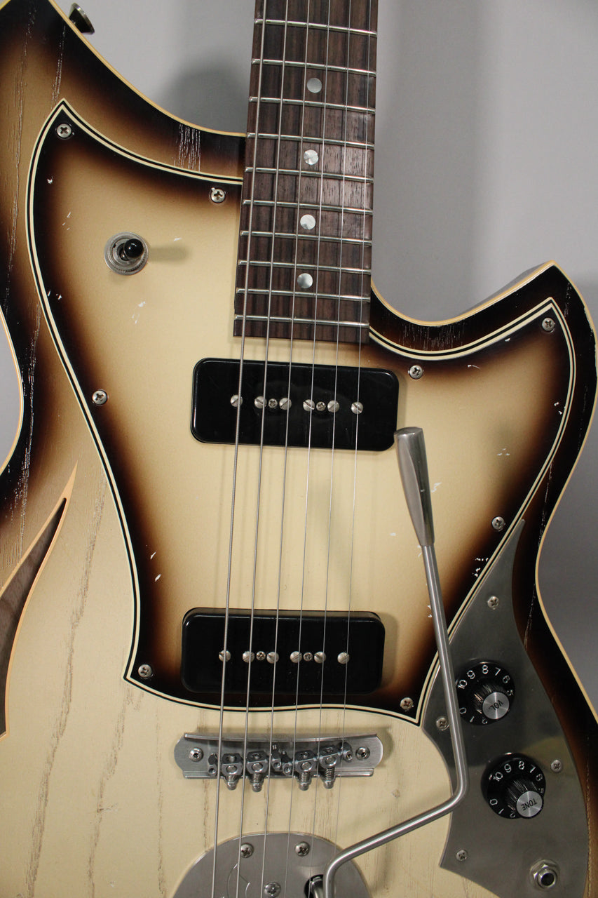 Close-up of the guitar body, showing the toasted marshmallow finish, two black P90 pickups, and a vibrato arm.