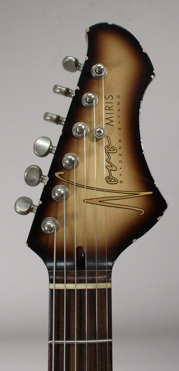 Close-up of the guitar's headstock, showing a brown-to-tan sunburst finish with light aging and six aged chrome tuners.