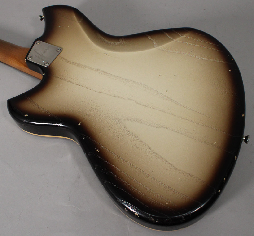 The back of a semi-hollow guitar with a brown-to-cream sunburst finish, showing extensive finish checking and wear around the edges.
