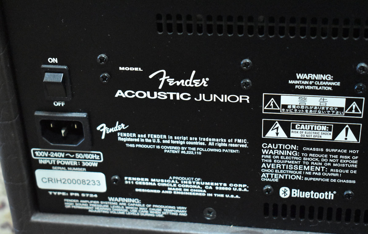 The amp's black rear panel shows the power switch, AC input, and various warning labels, with a visible serial number.