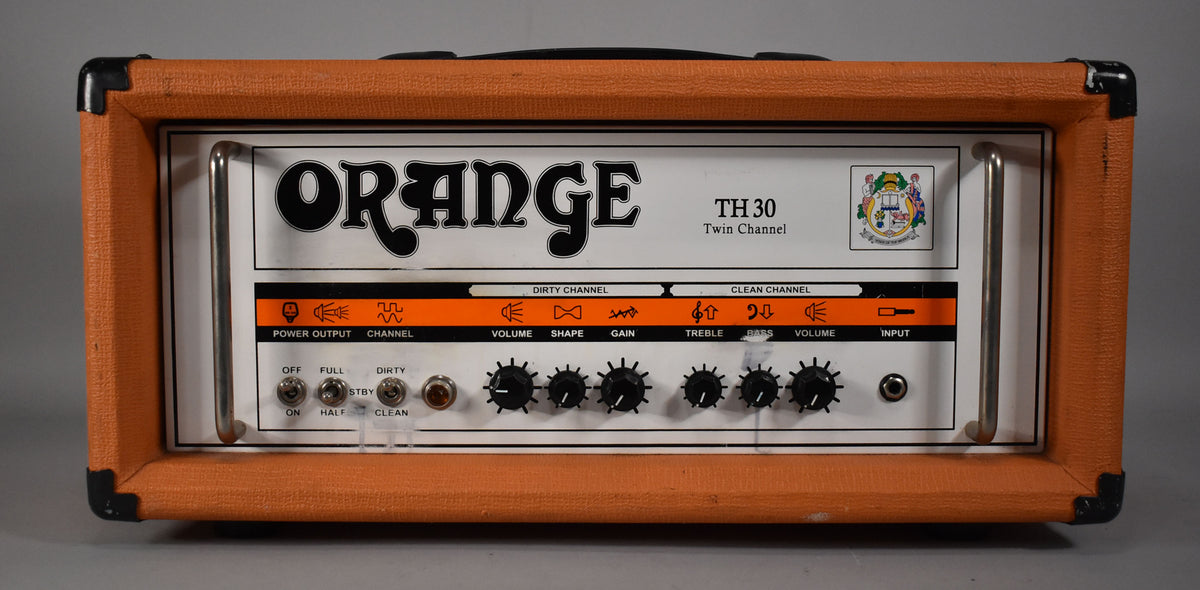 Front view of an Orange TH 30 amp head, showing its orange textured Tolex, black corner protectors, and white control panel with black knobs.