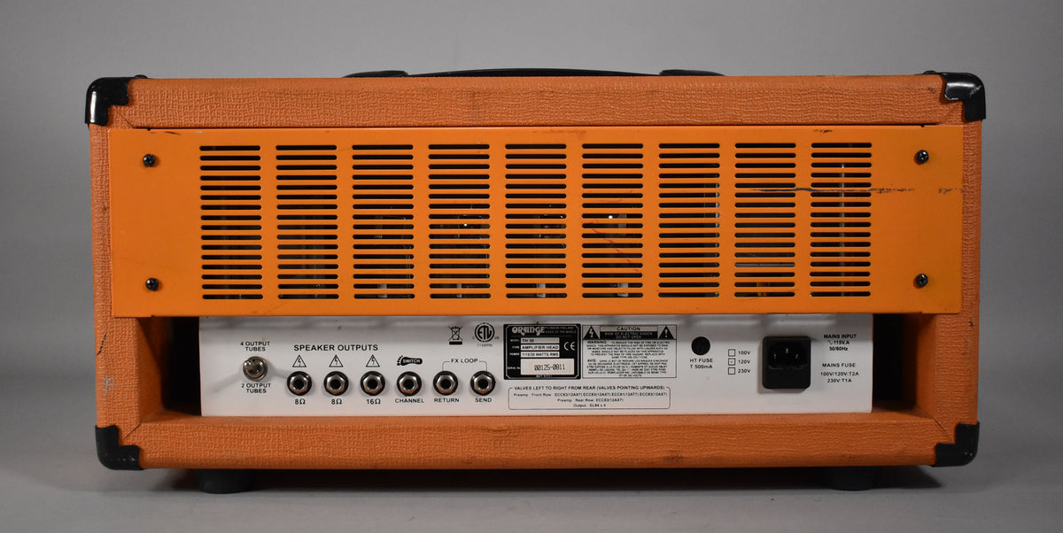 Rear view of an orange amplifier head, showing the vented metal panel, speaker outputs, FX loop, and power input.