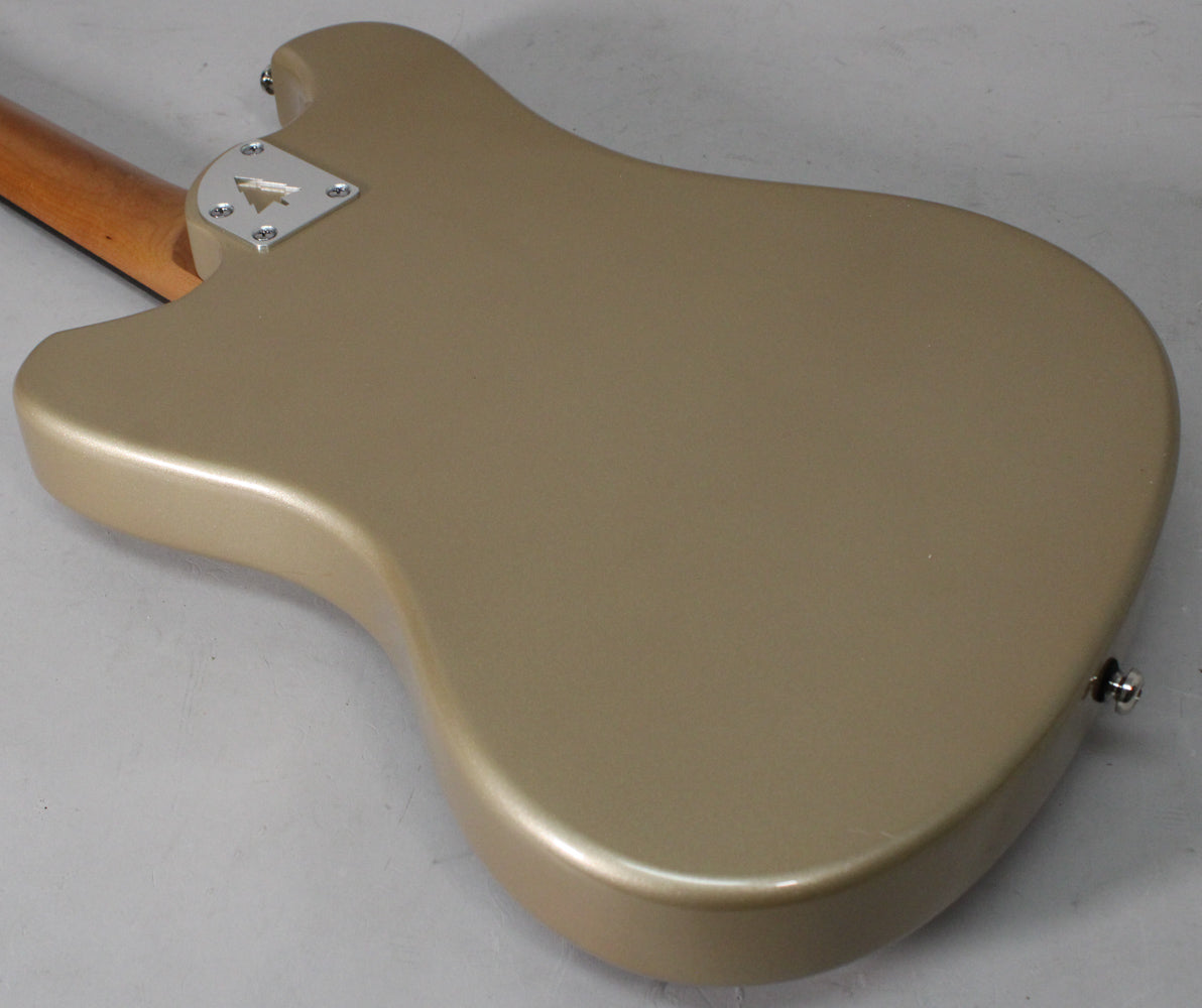 The back of the sandstone-colored guitar body, showing the neck joint plate, a strap button, and a small chip on the lower edge.