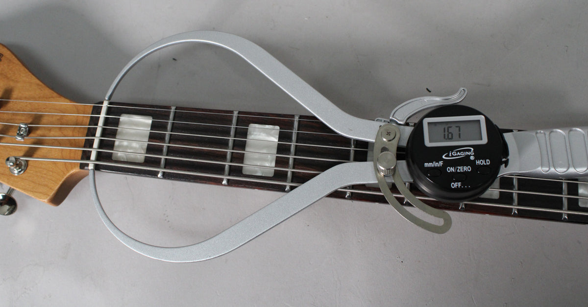 Close-up of the guitar's fretboard with a digital caliper measuring the nut width at 1.67 inches.