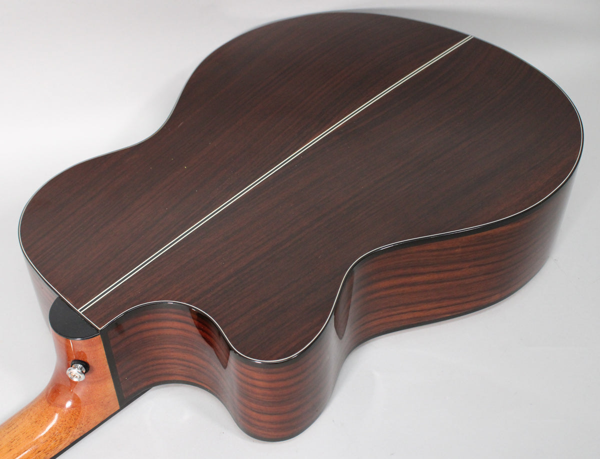The guitar's dark reddish-brown back and sides are visible from a high angle, with two light stripes down the back.