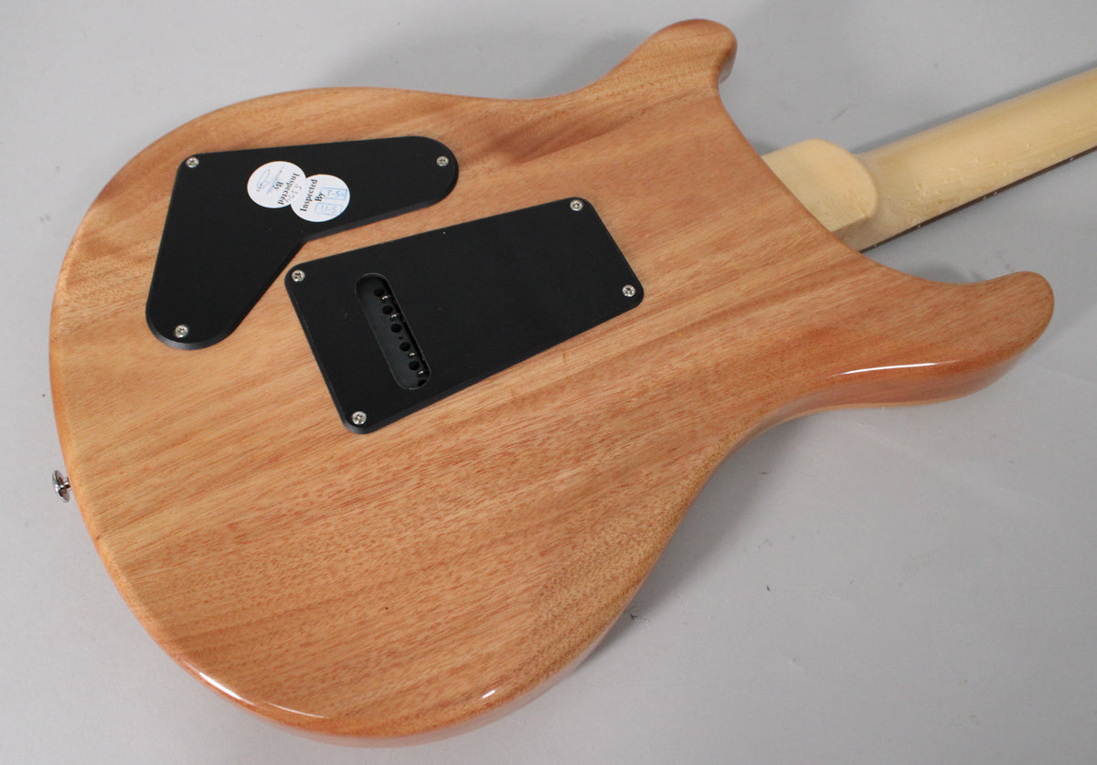 The guitar's back, angled from the lower bout, shows a natural wood finish, black control cavity covers, and a light-colored neck.