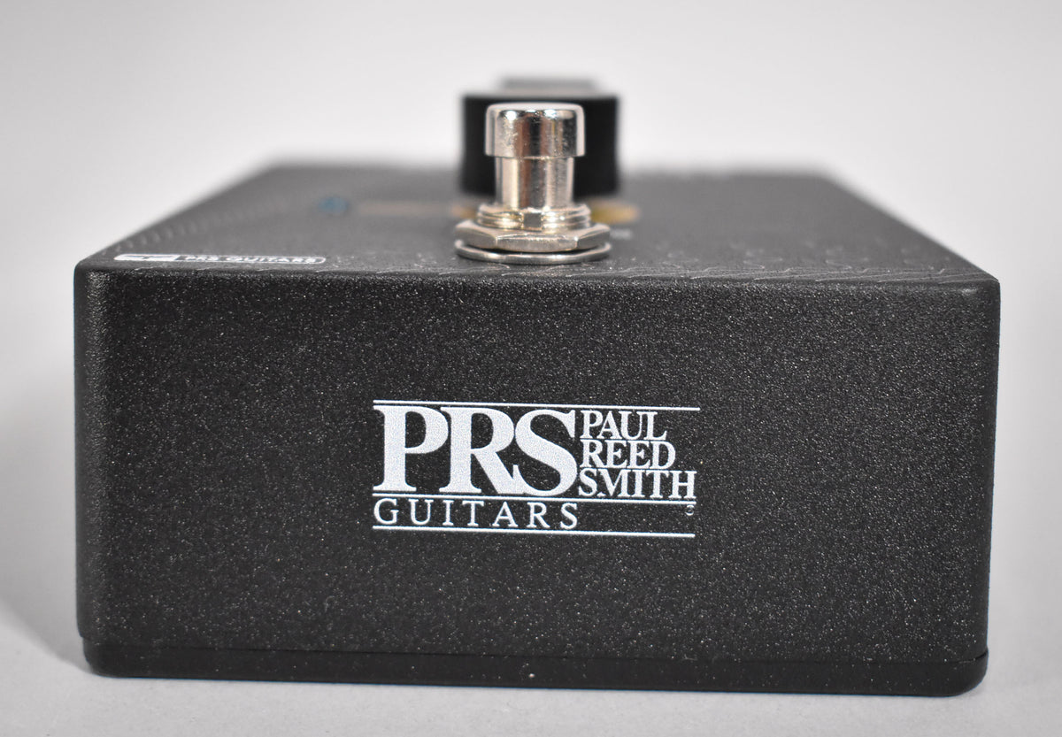 The black textured pedal is viewed from the front, showing the white PRS Guitars logo and a silver footswitch on top.